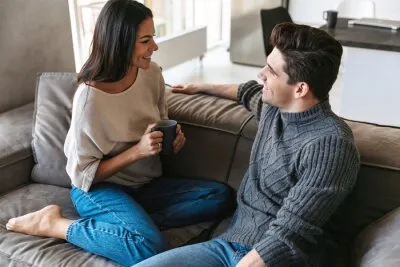 කාන්තාවකට රැකියාව සහ පවුල් ජීවිතය සමබර කරගැනීමට උපක්රම 4 happy young couple sitting on a couch at home 400 153233375